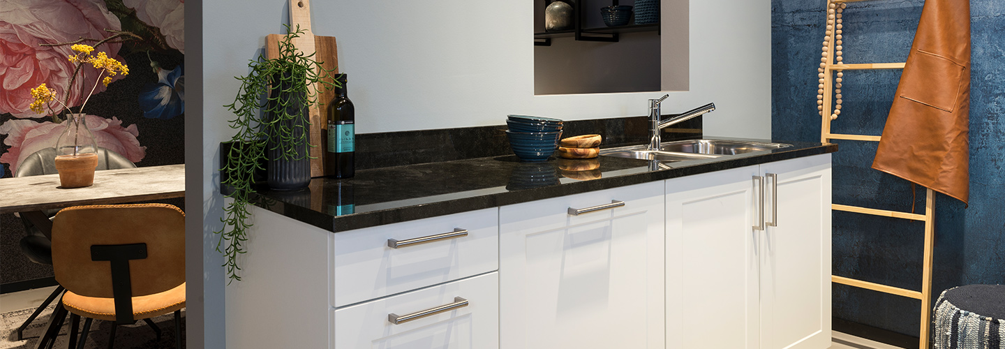 witte keuken met zwart granieten aanrechtblad